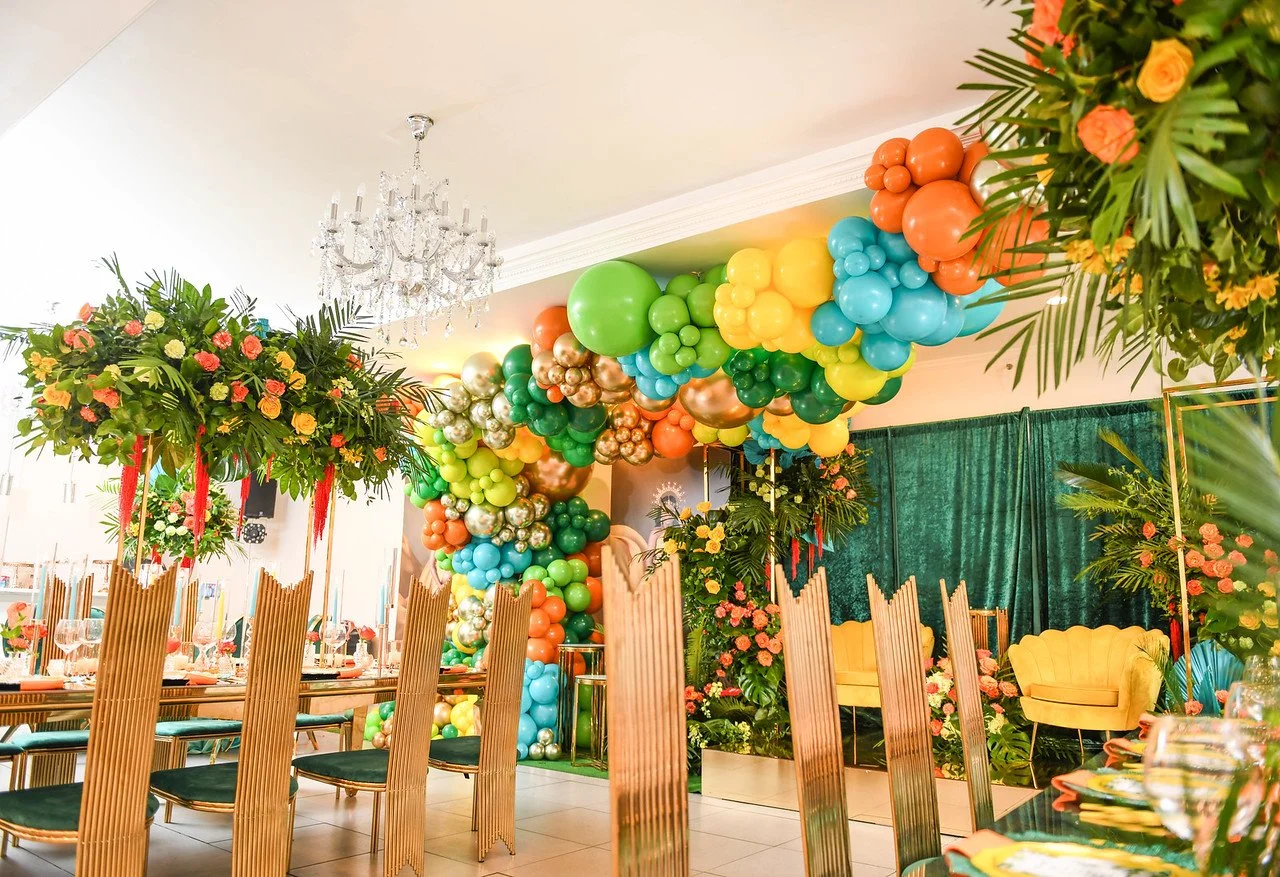 RSVP Brooklyn venue with colorful balloon decor, tropical flowers, and gold dining chairs